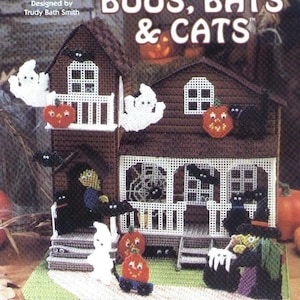 May include: A Halloween-themed needlecraft project featuring a brown house decorated with ghosts, bats, pumpkins, and black cats. The text "Halloween BOOS, BATS & CATS" is displayed above the house. The project is designed by Trudy Bath Smith and is made on 7-count plastic canvas.