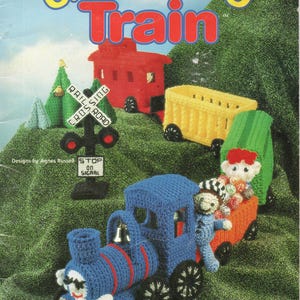 May include: A crochet pattern for a colorful "Choo Choo Train" toy. The image shows a blue train with red accents, a red caboose, and yellow and orange train cars. The text reads "Choo Choo Train" and "Take a ride on this choo choo express for hours of play with your child!"
