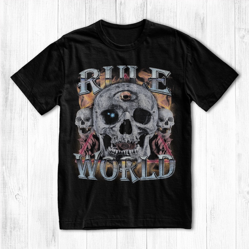 May include: Black t-shirt with a graphic print of a skull with a third eye and the text "RULE WORLD" in a vintage style.