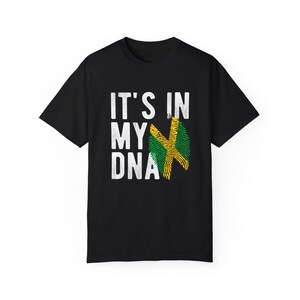 Può includere: Maglietta nera con testo bianco che recita "It's in my DNA" e un design di impronta digitale verde, giallo e nero.