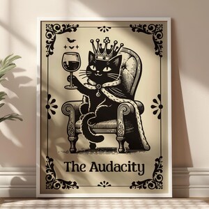 May include: Framed black and white illustration of a regal black cat wearing a crown and cape, seated on a throne, holding a wine glass. The text "The Audacity" is below the cat. The frame has decorative flourishes.