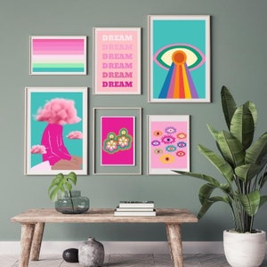 May include: A collection of framed art prints with a retro, psychedelic theme. The prints feature vibrant colors and bold designs, including an eye with a rainbow, the word "DREAM", and floral earrings. The artwork is displayed on a green wall.
