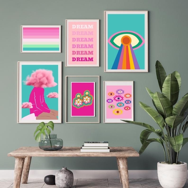 May include: A collection of framed art prints with a retro, psychedelic theme. The prints feature vibrant colors and bold designs, including an eye with a rainbow, the word "DREAM", and floral earrings. The artwork is displayed on a green wall.