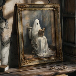 May include: A framed painting of a ghost sitting on a toilet and reading a book. The ghost is wearing a white sheet and has two black eyes. The painting is set in a bathroom with a tiled floor.
