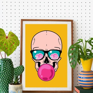 May include: A framed print of a cartoon skull wearing sunglasses and blowing a pink bubble. The background is yellow.
