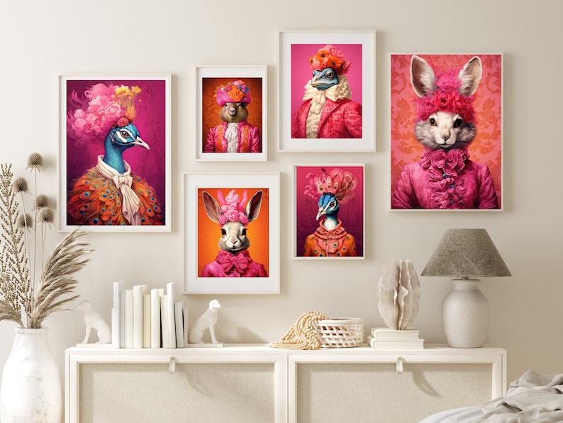 May include: Five framed prints of animals wearing elaborate pink and orange costumes and hats. The animals are a peacock, a rabbit, a squirrel, a lizard, and a bird. The prints are displayed on a white wall above a white dresser.