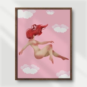 May include: A framed art print featuring a nude figure with flowing red hair floating in a pink sky with white clouds. The artwork has a soft, painterly style and is framed in a dark brown wooden frame.