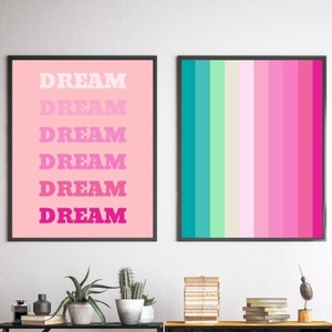 May include: Two framed art prints. One features the word "DREAM" in a gradient of pink hues against a pink background. The other print displays vertical stripes in shades of teal, green, pink, and magenta.