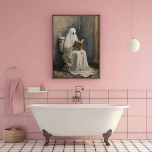 May include: A white ghost wearing a sheet sits on a toilet and reads a book in a bathroom with pink walls and white tile.