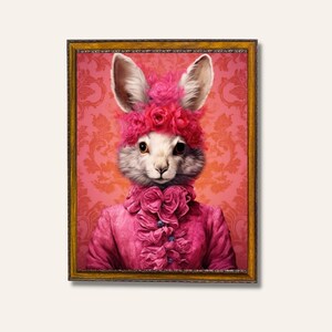 May include: A white rabbit wearing a pink ruffled dress and a pink flower crown. The rabbit is framed in a gold frame against a pink and white damask background.