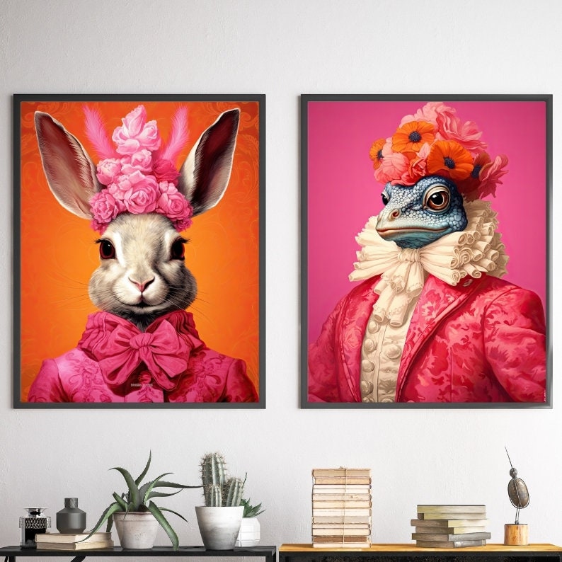 May include: Two framed prints of animals wearing fancy clothing. The first print features a rabbit wearing a pink dress and a crown of flowers. The second print features a frog wearing a red jacket and a white ruffled collar.