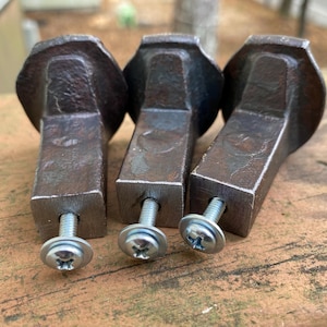 May include: Three rustic metal drawer pulls with a square base and a rounded top. Each pull has a silver screw.
