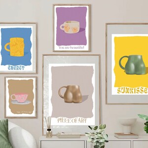 Peut inclure: Cinq impressions encadrées avec des fonds de couleurs différentes et des tasses aux motifs variés. Les impressions comportent les textes suivants : "Energy", "You are beautiful", "Sunkissed", "Piece of Art", et "The laughter of..."