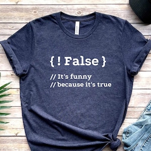 May include: A navy blue t-shirt with white text that reads "{!False} // It's funny // because it's true".