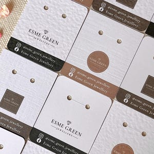 May include: A selection of white and brown jewellery display cards. Each card displays the "ESME GREEN JEWELLERY" logo, social media details, and holes for earrings. The cards have a textured finish.