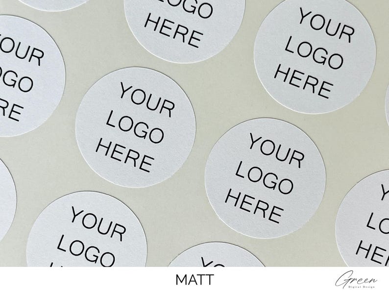 May include: A collection of circular white stickers arranged in a pattern. Each sticker features the black printed text "YOUR LOGO HERE" centered in a clean, sans-serif font. The stickers have a matte finish and are presented on a light background.