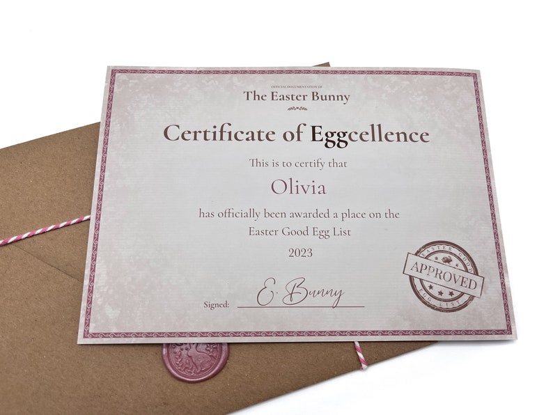 May include: A certificate of Eggcellence, signed by the Easter Bunny, is awarded to Olivia for being on the Easter Good Egg List in 2023. The certificate has a pink border and a red wax seal.