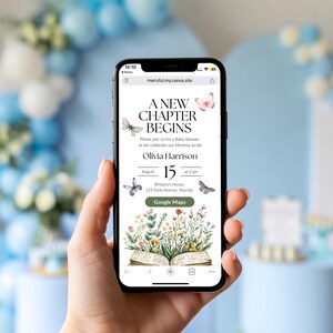 May include: A mobile phone screen shows a baby shower invitation with the text "A New Chapter Begins." The invitation includes butterfly and floral designs. The date is August 15th at 2 pm. The phone is held in a hand, with a blurred background of blue and white decorations.