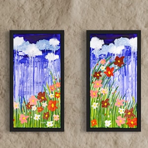 May include: Two framed paintings depicting a blue sky with white clouds and rain falling. The bottom of each painting shows a field of green grass with colourful flowers.