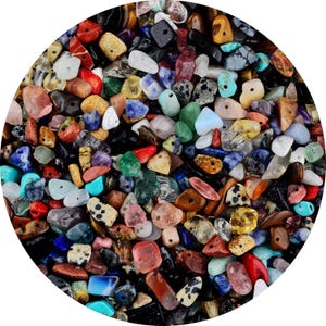 May include: A circular arrangement of polished gemstones in various colors, including red, blue, green, yellow, and black. The stones vary in size and shape, creating a textured surface. The gemstones appear to be natural and are likely used for jewelry or decorative purposes.