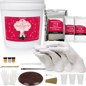 May include: A white plastic bucket labelled The Unique Gift Hard Cast Kit, a silver bag of 600g alginate powder, two 500g casting powder bags, three small paint pots, a wooden base, a brush, a spatula, two gloves, and three measuring cups.