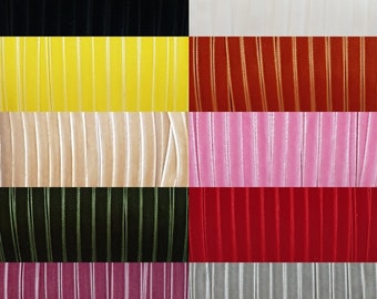 Könnte beinhalten: Sortiment aus zehn Farben von 6 mm breitem Samtband. Die Farben sind Schwarz, Gelb, Orange, Beige, Grün, Rot, Rosa, Grau und zwei Rosatöne.