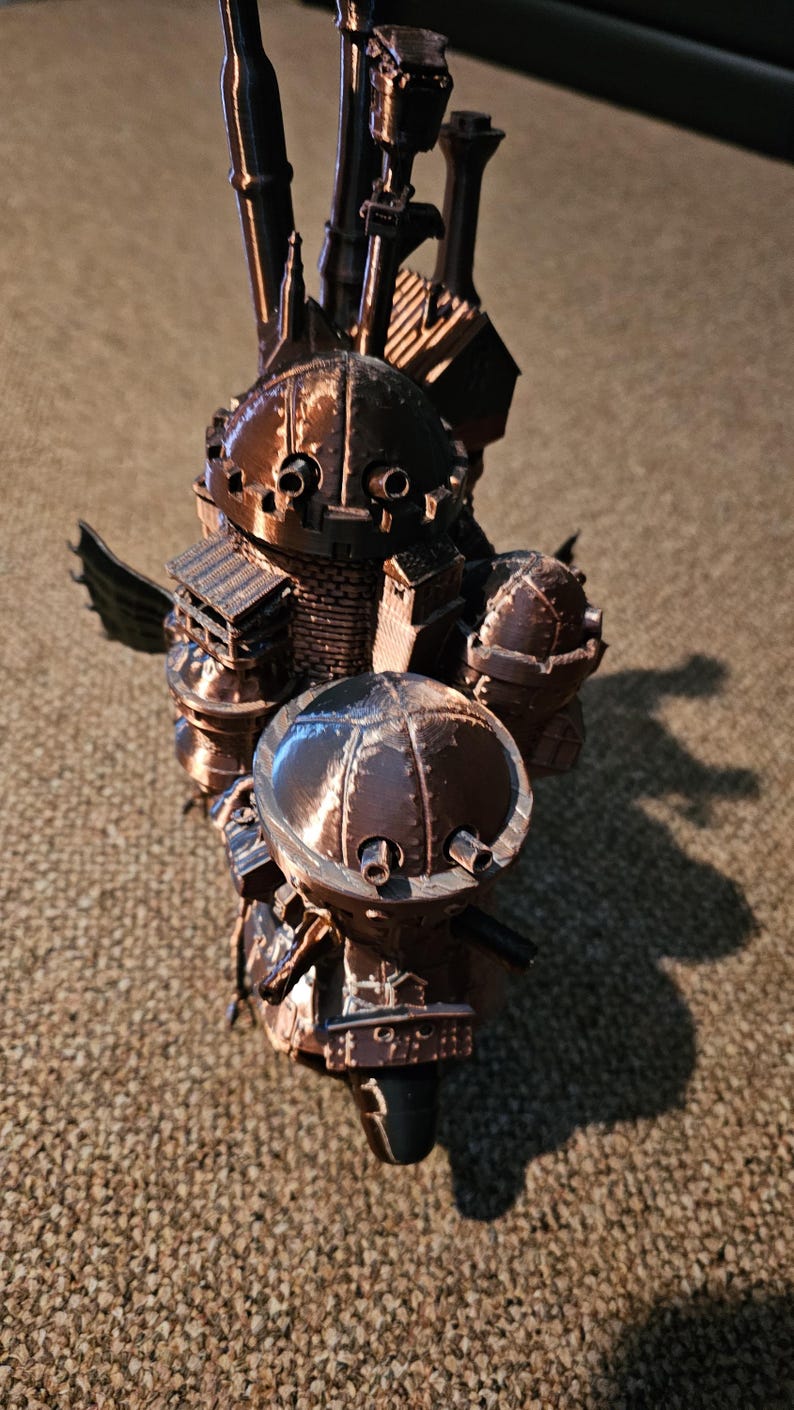 Op de afbeelding: Een 3D-geprint model van een vliegend steampunk kasteel met meerdere torens, schoorstenen en een grote koepel. Het model is gemaakt van bruin plastic en heeft een gedetailleerd ontwerp.