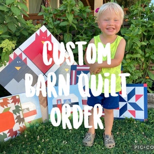 May include: A young child stands in front of a variety of colorful quilt blocks. The blocks feature different designs, including a rooster, a barn, and a pumpkin. The text "CUSTOM BARN QUILT ORDER" is superimposed on the image.
