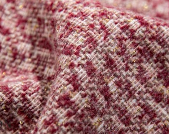 May include: Close-up of a red and white tweed fabric with gold thread woven throughout.