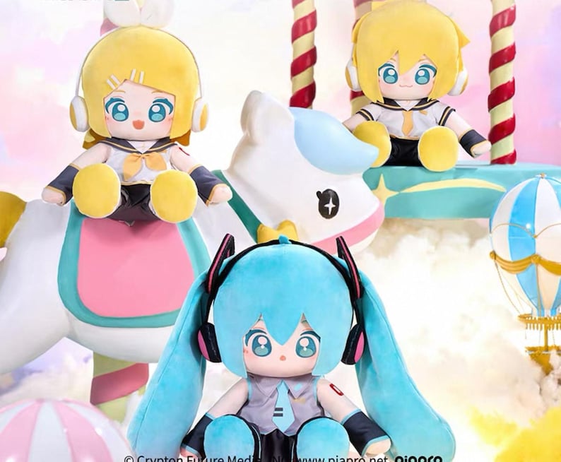May include: Three plush dolls with large eyes and headphones. Two dolls have yellow hair and one has blue hair. The dolls are wearing sailor-style outfits. The dolls are sitting on a carousel-like structure with a white horse.