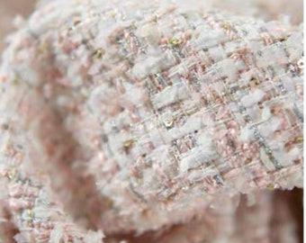 May include: Close-up of a pink and white tweed fabric with silver and gold threads woven throughout.