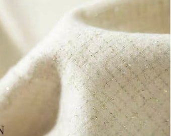 May include: Close-up of a white fabric with a subtle shimmer. The fabric has a textured weave and a soft, luxurious feel.