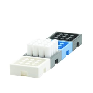 Op de afbeelding: Een set van drie witte, blauwe en zwarte plastic containers met een rasterpatroon. De containers zijn op elkaar gestapeld. De bovenste container heeft een wit rasterpatroon en is gevuld met witte cilindrische objecten.