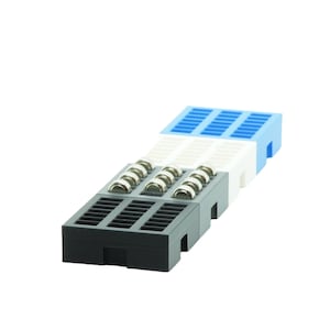 Könnte beinhalten: Drei übereinander gestapelte Plastik-Brotbretter mit einem Gittermuster. Das obere Brett ist blau, das mittlere Brett ist weiß und das untere Brett ist schwarz. Die Bretter haben kleine Metallrollen an der Unterseite.