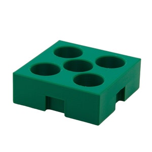 Pode incluir: Um bloco retangular verde sólido com cinco orifícios circulares. O bloco tem um design escalonado nas laterais e é feito de um material liso e fosco. Os orifícios são espaçados uniformemente na superfície superior.
