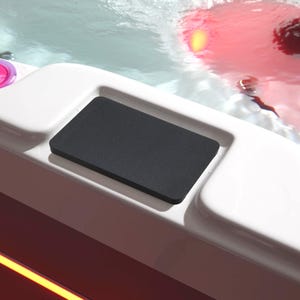 Könnte beinhalten: Ein weißer Whirlpool mit einem schwarzen Bedienfeld und einem rosa Licht. Der Whirlpool ist mit Wasser gefüllt und ein rotes Licht leuchtet auf der Oberfläche.