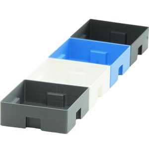 May include: Four empty plastic storage containers stacked on top of each other. The containers are grey, white, and blue.