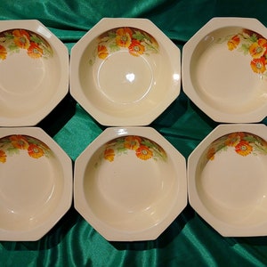 Puede incluir: Juego de seis cuencos de cerámica octogonales blancos con un diseño floral con amapolas naranjas y hojas verdes. Los cuencos están dispuestos en dos filas de tres.