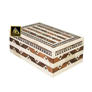 May include: A rectangular decorative box with a geometric pattern. The box features alternating bands of light and dark wood, creating a striking visual contrast. The sides and top are adorned with intricate triangular and linear designs. The box is a decorative storage item.