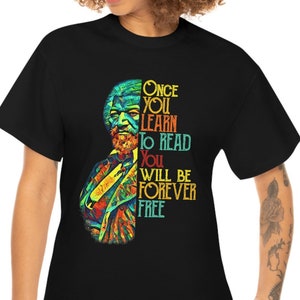 Puede incluir: Camiseta negra con una ilustración colorida de una persona y el texto "Once you learn to read you will be forever free".