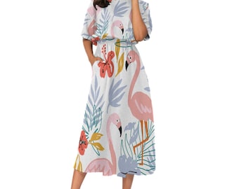 May include: A white midi dress with a pink flamingo and floral print. The dress has a round neckline, short sleeves, and a gathered waist.