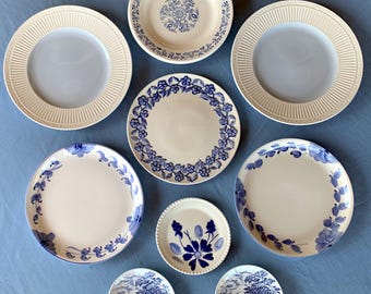 May include: Nine blue and white ceramic plates with floral designs. The plates are arranged in a circle on a blue surface.