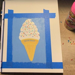 Pu&ograve; includere: Dipinto di un cono gelato su sfondo azzurro, fissato a una superficie bianca con nastro adesivo blu. Il gelato ha un gelato soft bianco con granelli colorati e un cono giallo. Il testo "KOHR BROS" &egrave; sul cono.