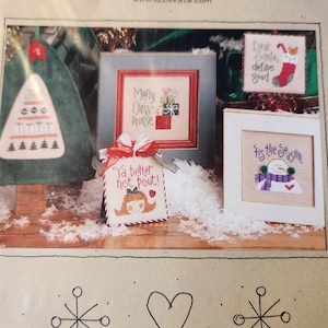 May include: A collection of cross-stitch patterns for Christmas, featuring a snowman, a girl, a Christmas tree, and a stocking. The patterns are framed in white and have a rustic, vintage feel. The text on the patterns reads "Tis the Season", "Ya better not pout!" "Merry Chris Mouse", and "Dear Santa, define good". The text at the bottom of the image reads "Tiny Tidings XI".