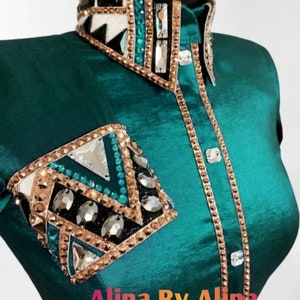 K&ouml;nnte beinhalten: Tealfarbenes Westernhemd mit goldenen Verzierungen, geometrischem Muster und Strasssteinen. Das Hemd hat einen Kragen und einen Knopfleistenverschluss. Der Text "Alina By Alina" ist am unteren Rand des Hemdes sichtbar.