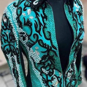 May include: A turquoise and black show jacket with a zipper closure and intricate beading and embroidery. The jacket has a collar and long sleeves.