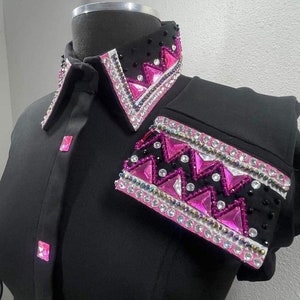 May include: Black show shirt with a pink and white geometric design on the collar and shoulder. The design features rhinestones and sequins.