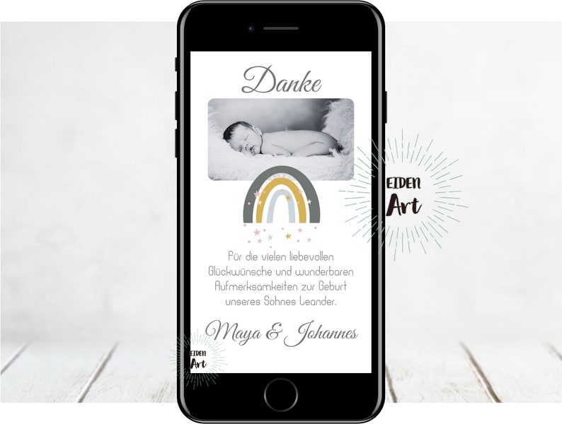 May include: A smartphone screen displaying a thank you message with a rainbow and stars graphic. The message reads "Danke" and "For the many loving wishes and wonderful attentions for the birth of our son Leander. Maya & Johannes". The screen also displays the text "EIDEN Art".