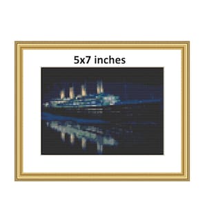 Puede incluir: Un patrón de punto de cruz enmarcado del RMS Titanic de noche, con las luces del barco iluminadas. El patrón mide 5x7 pulgadas.
