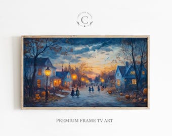 May include: A framed print of a twilight village scene with houses, streetlights, and figures walking on a road. The artwork has a warm color palette with orange and blue hues. Pumpkins are placed in front of the houses. The text "PREMIUM FRAME TV ART" is at the bottom.